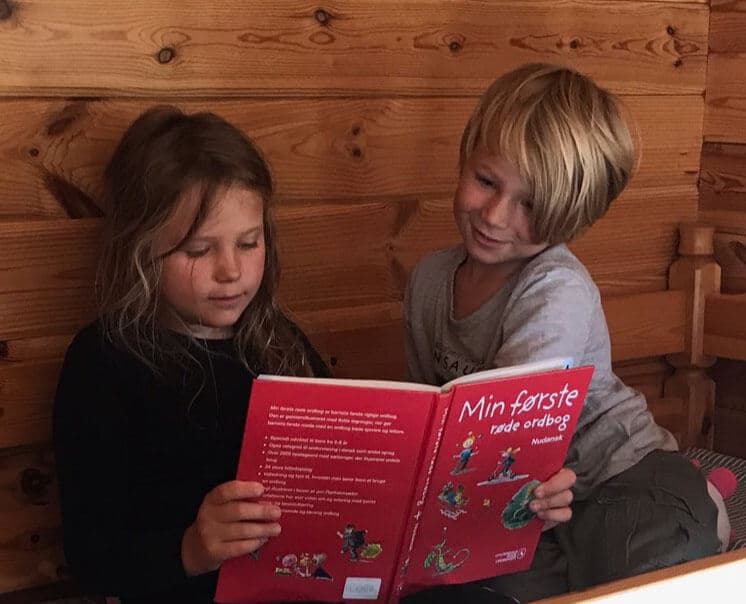 En lille dreng og pige der læser en bog.